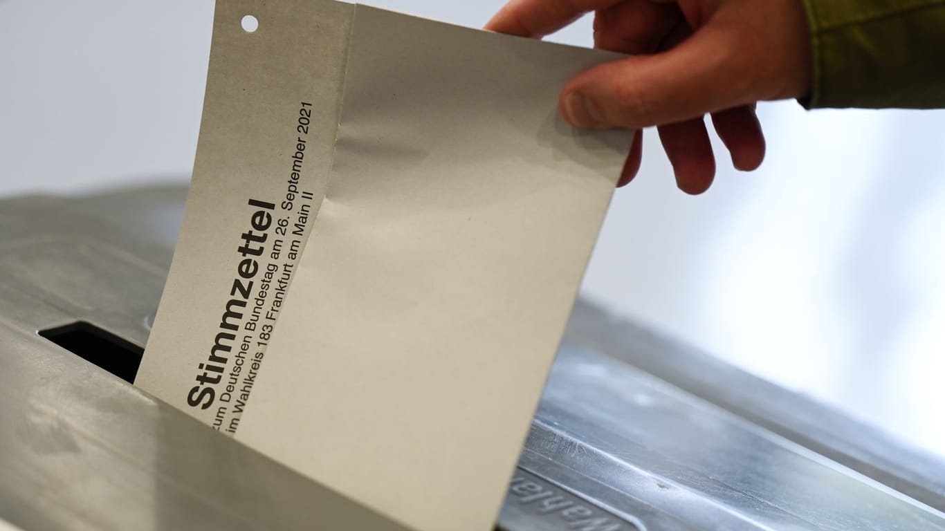 Stimmzettel wird in eine Wahlurne gesteckt