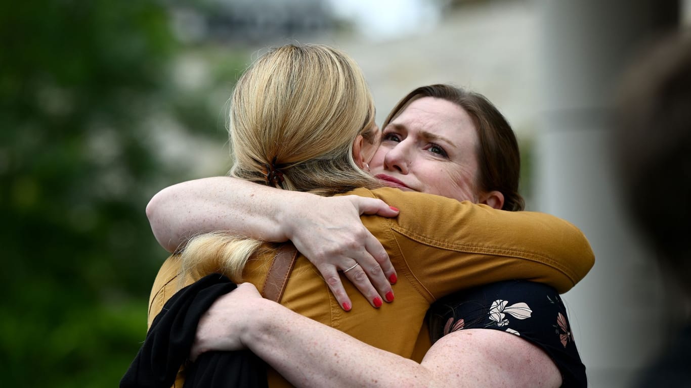 Eine Unterstützerin umarmt Christina Strobel (l), die Schwester von Simone Strobel, vor dem Lidcombe Coroners Court.