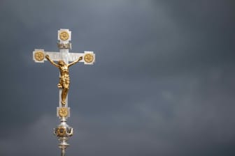 Ein Kruzifix vor dunklen Wolken