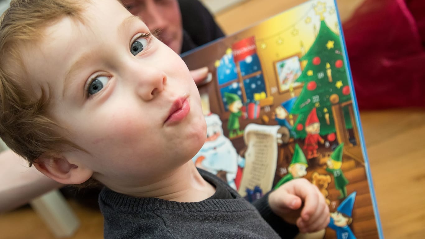 Ein kleiner Junge öffnet einen Adventskalender (Symbolbild): Eltern sollten beim Kauf vorsichtig sein.