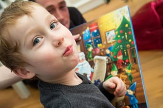 Ein kleiner Junge öffnet einen Adventskalender (Symbolbild): Eltern sollten beim Kauf vorsichtig sein.