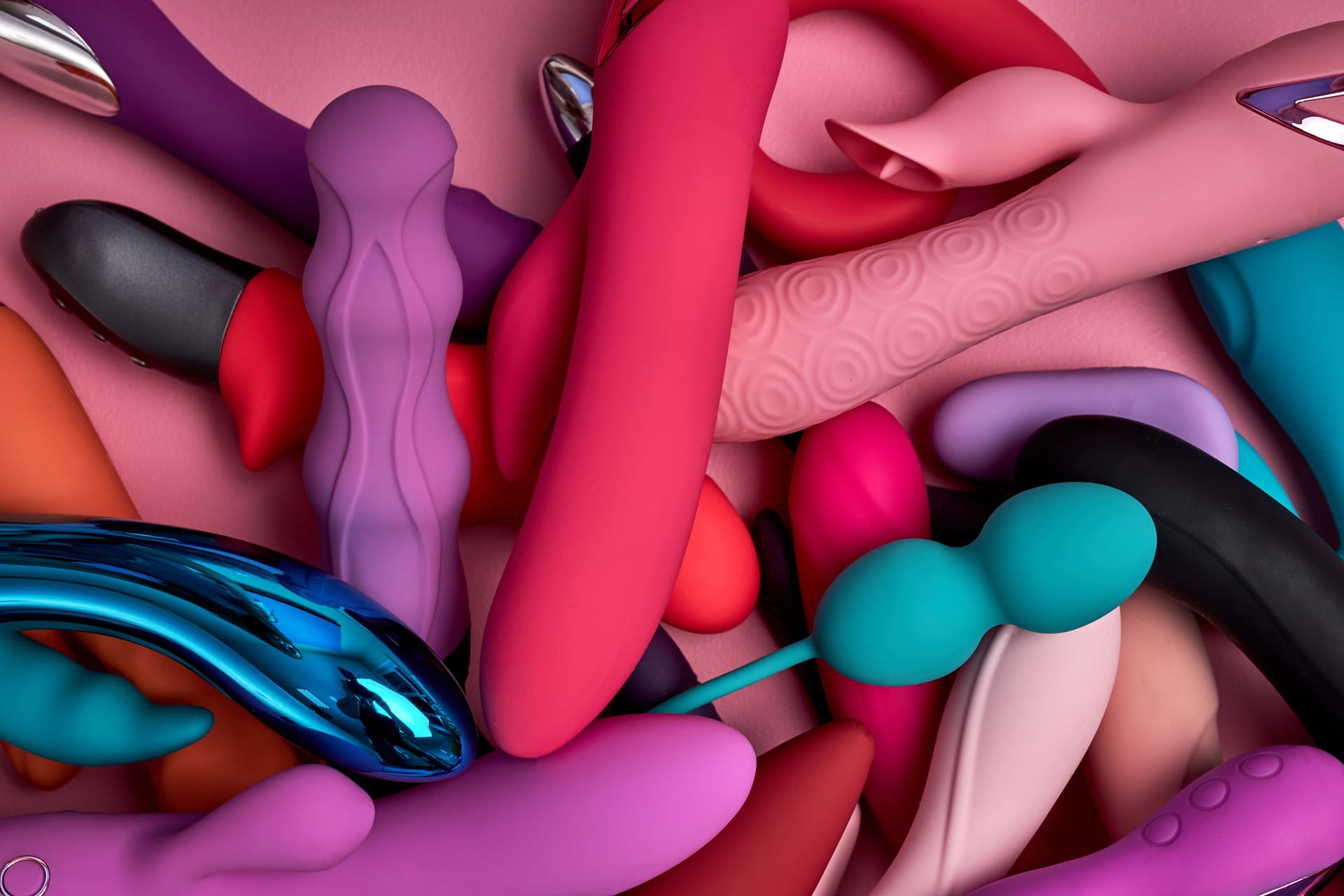 Bright stack of rubber sex toys flat lay