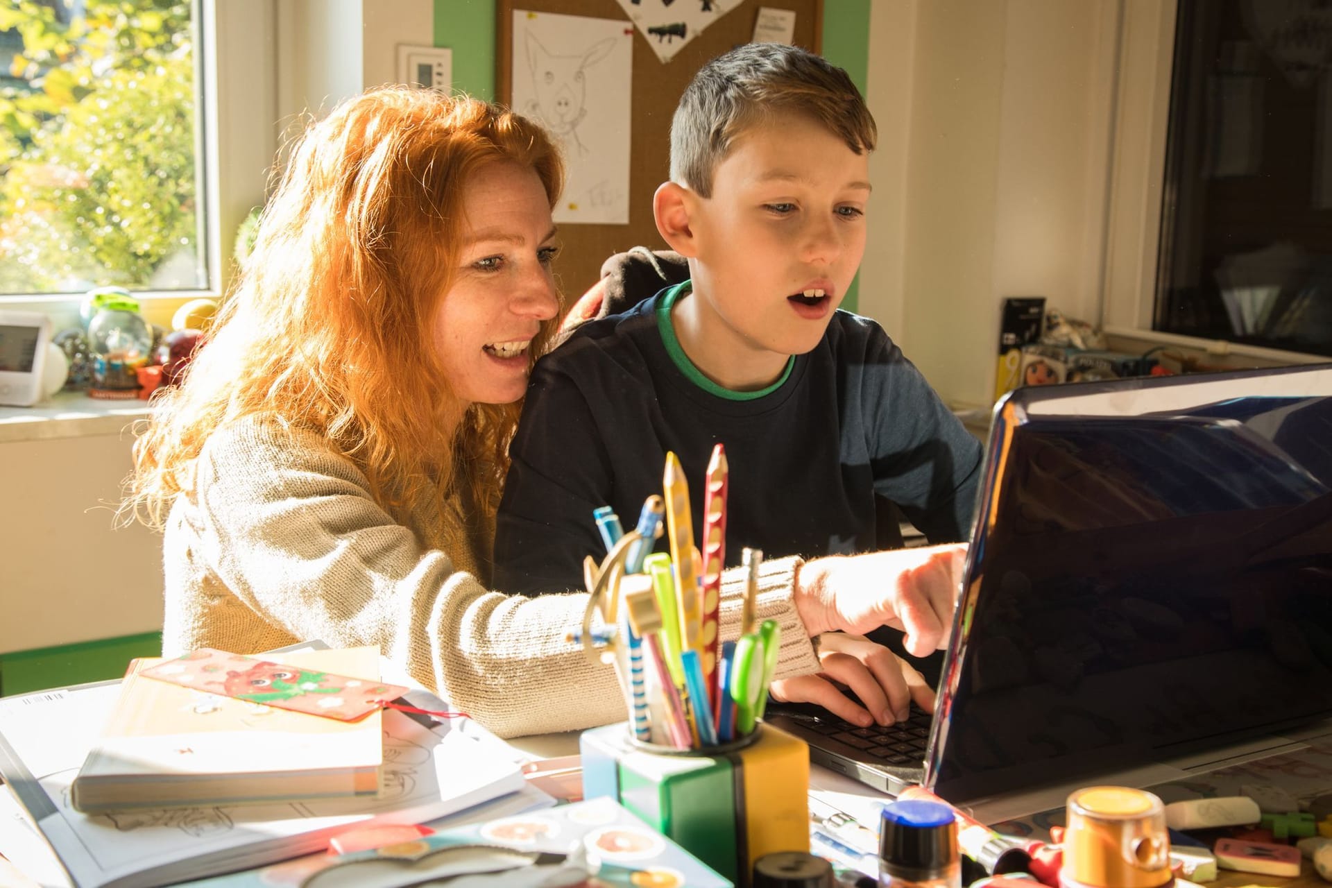 Mutter und Sohn sitzen gemeinsam vor einem Laptop