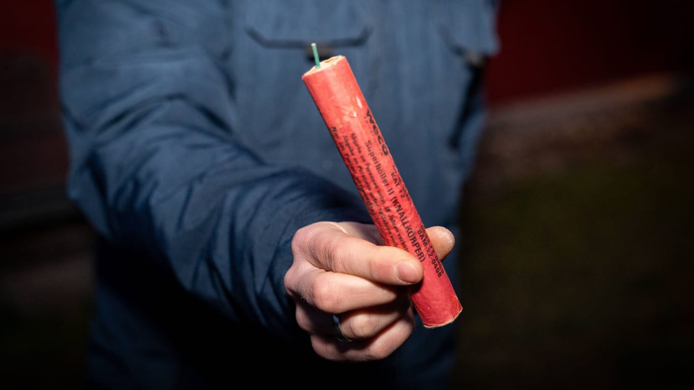 Kammlach, Bavaria, Germany - December 31, 2023: Man holding a large firecracker outdoors on New Year s Eve