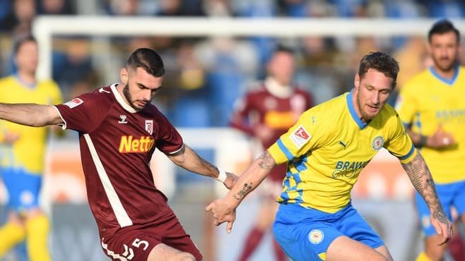 Regensburgs Rasim Bulic (l.) spielt gegen Braunschweigs Sebastian Polter: Braunschweig konnte beim Kellerduell keinen Sieg erzielen.