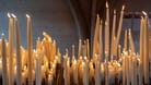 Burning candles lighted for belief or hope in Lourdes, France - Religion concept