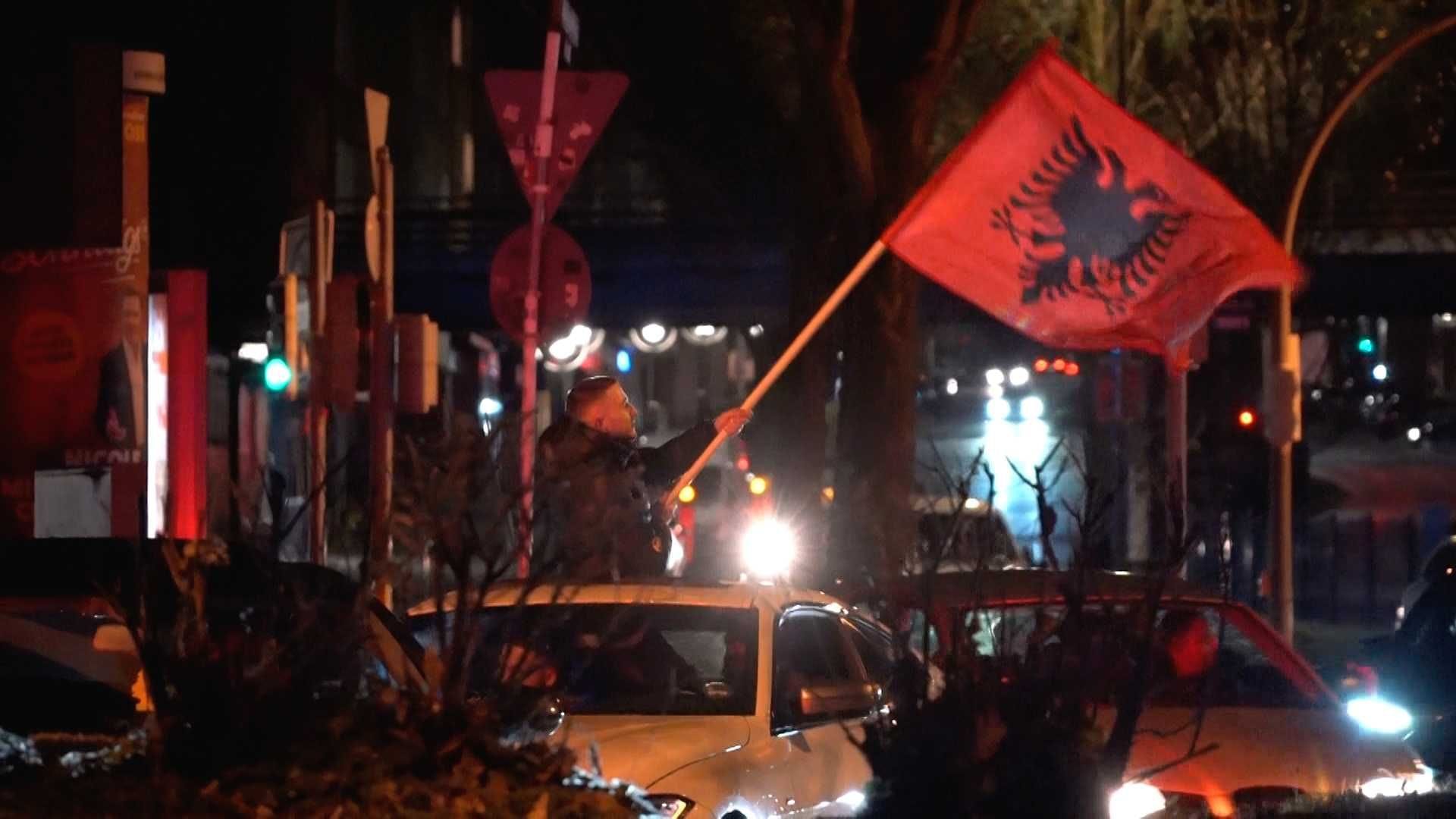 Albaner feiern: Ein Teilnehmer des Korsos lehnt sich mit einer Flagge aus dem Dachfenster eines Autos.