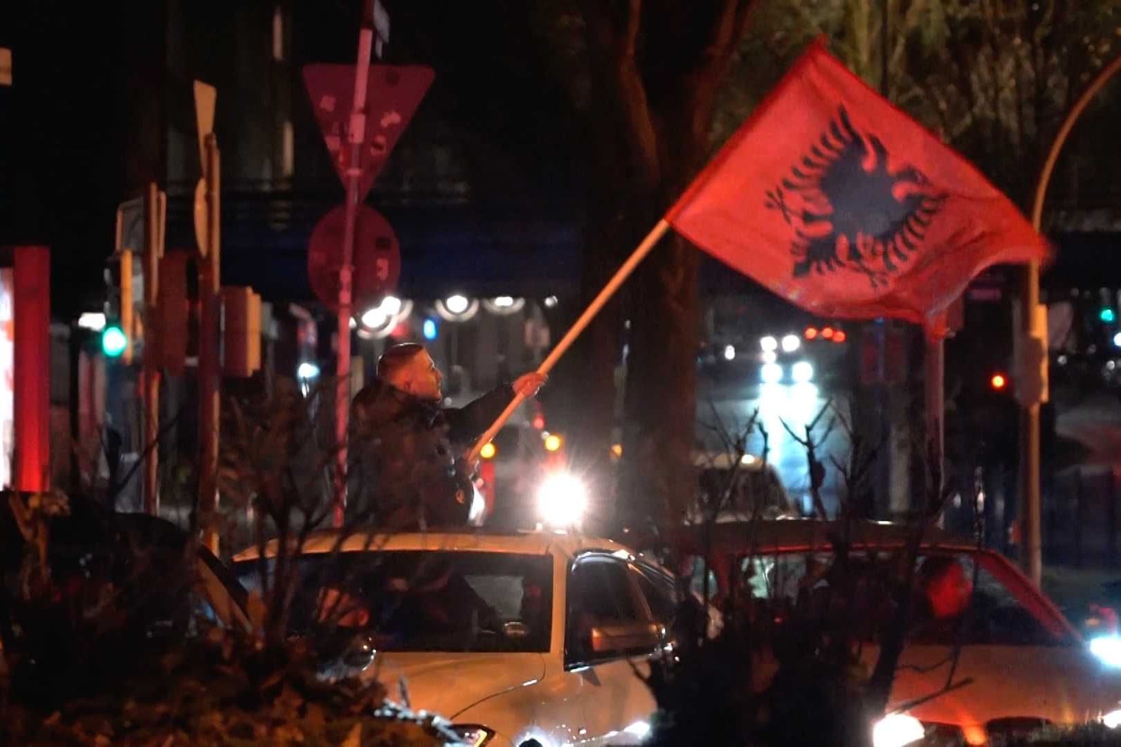 Albaner feiern: Ein Teilnehmer des Korsos lehnt sich mit einer Flagge aus dem Dachfenster eines Autos.