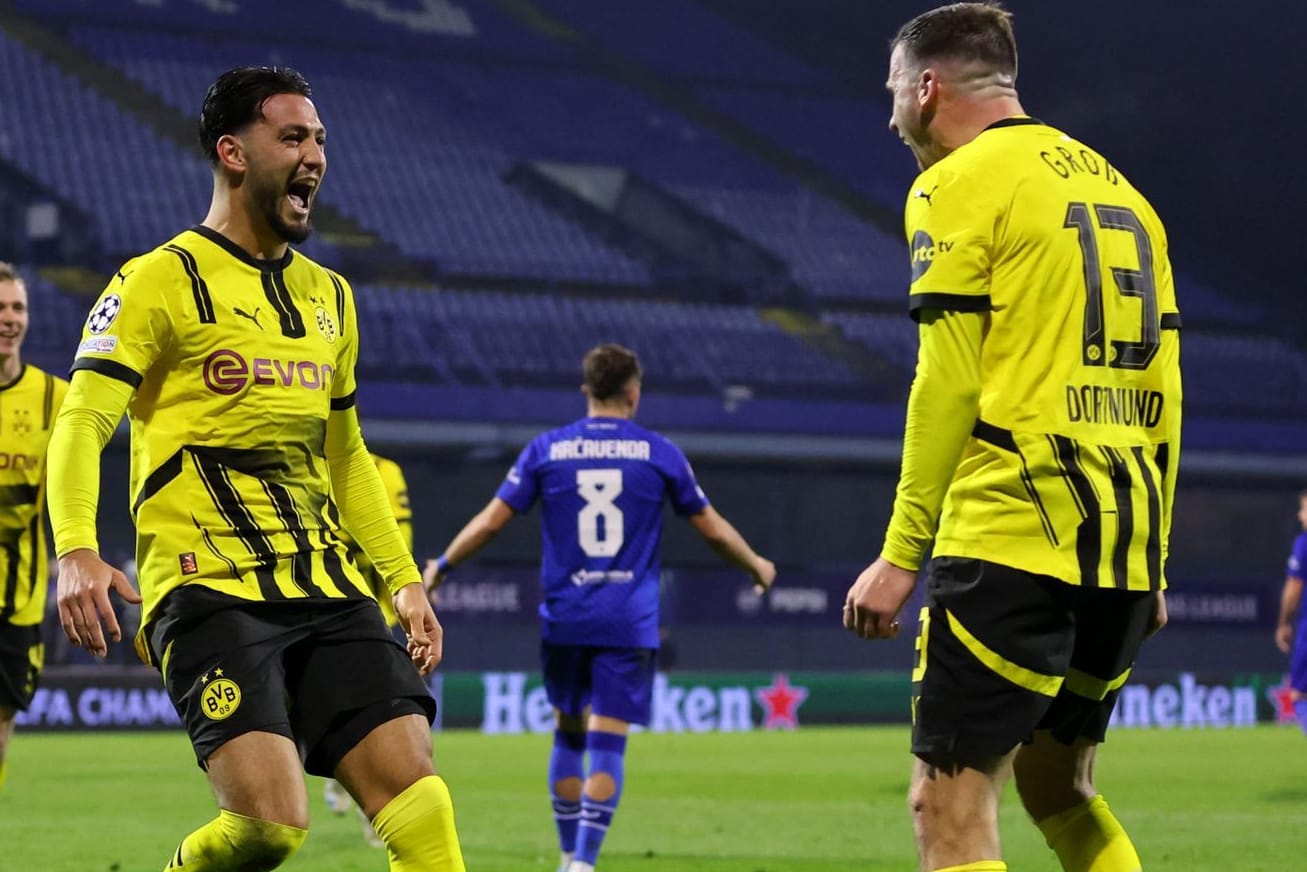 Pascal Groß (r.) feiert mit Ramy Bensebaini: Der BVB holte einen wichtigen Sieg in Zagreb.