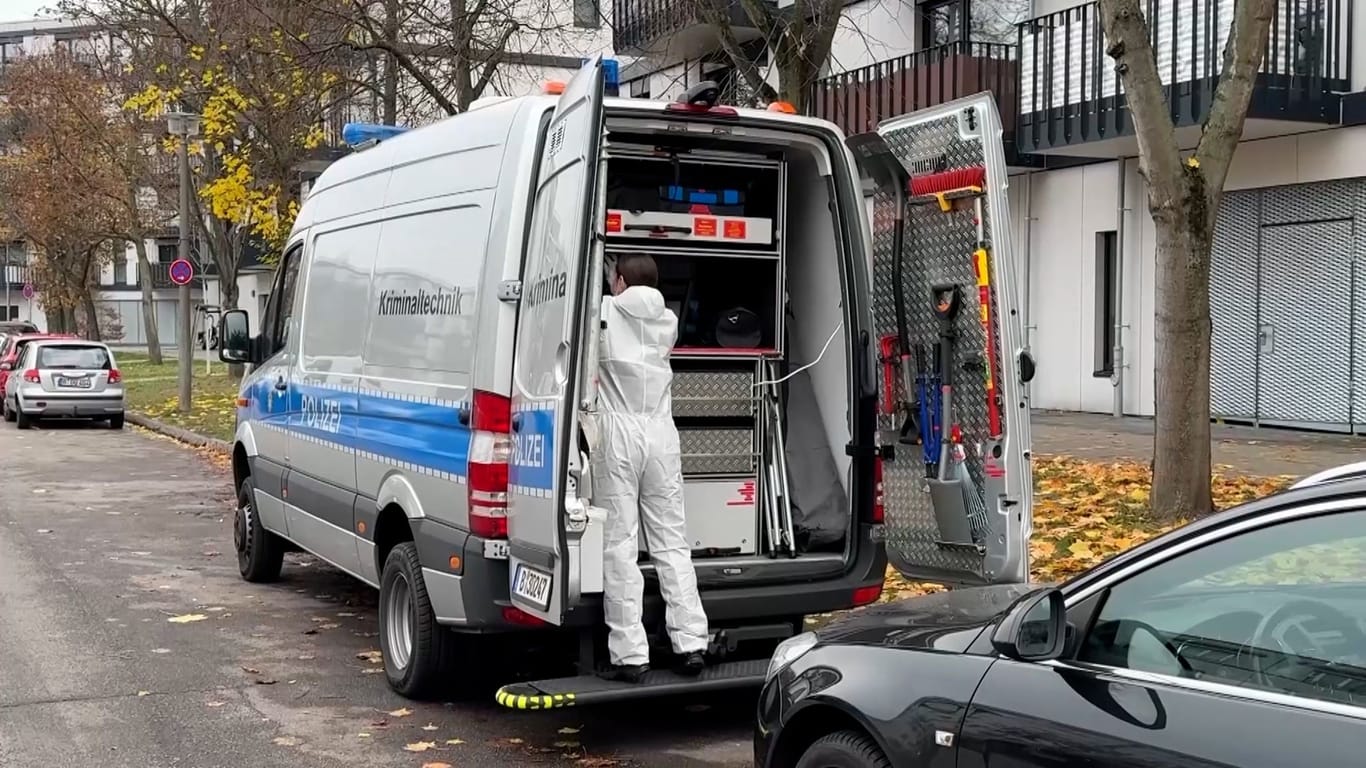 15.11.2024, Berlin: Eine Mitarbeiterin der Kriminaltechnik steht an einem geöffneten Einsatzfahrzeug. Rund zwei Wochen nach der Tötung einer Mutter und ihrer Töchter in Berlin-Marzahn hat die Polizei erneut nach Spuren gesucht in dem Haus, in dem die Leichen gefunden worden sind.