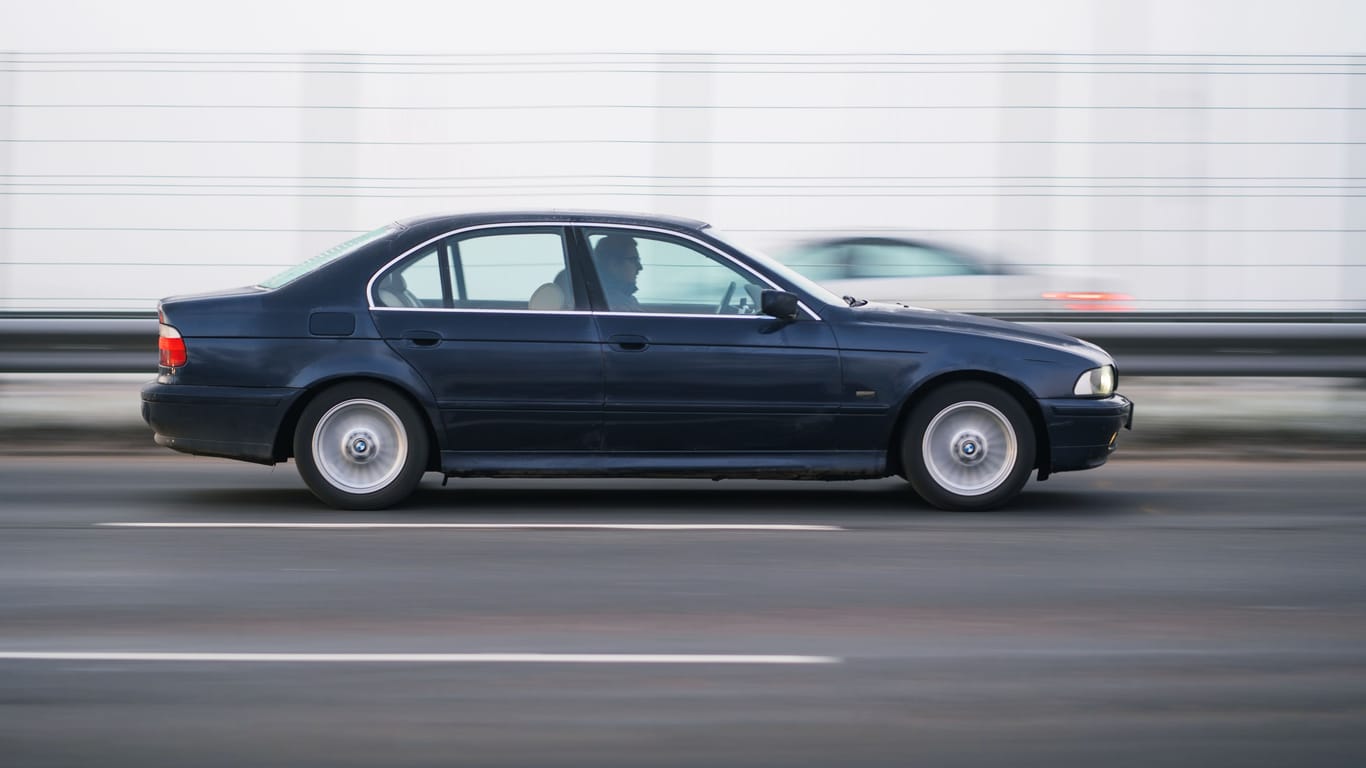 Riga, Latvia - November 15, 2021:Blue Business class sedan BMW E39 520 is driving fast on the highway, motion blur background