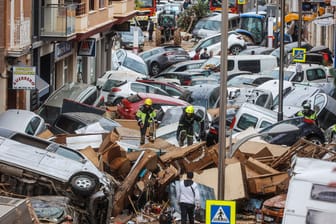 Feuerwehrleute suchen in den Trümmern nach Menschen.