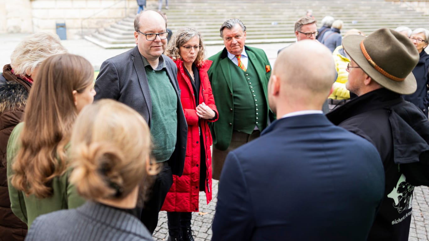 Niedersachsens Umweltminister Christian Meyer Il.) diskutiert mit Schafhalter Wendelin Schmücker: Die Demonstranten beklagen erhebliche Schäden durch Wölfe.