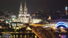 Kölner Dom und Hohenzollernbrücke im Dunkeln (Archivbild): Das Nachtleben fördert die Zufriedenheit der Menschen.