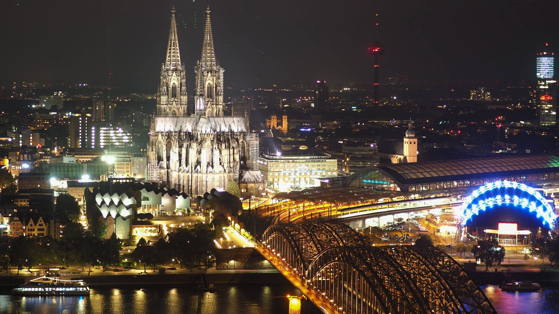 Kölner Dom und Hohenzollernbrücke im Dunkeln (Archivbild): Das Nachtleben fördert die Zufriedenheit der Menschen.