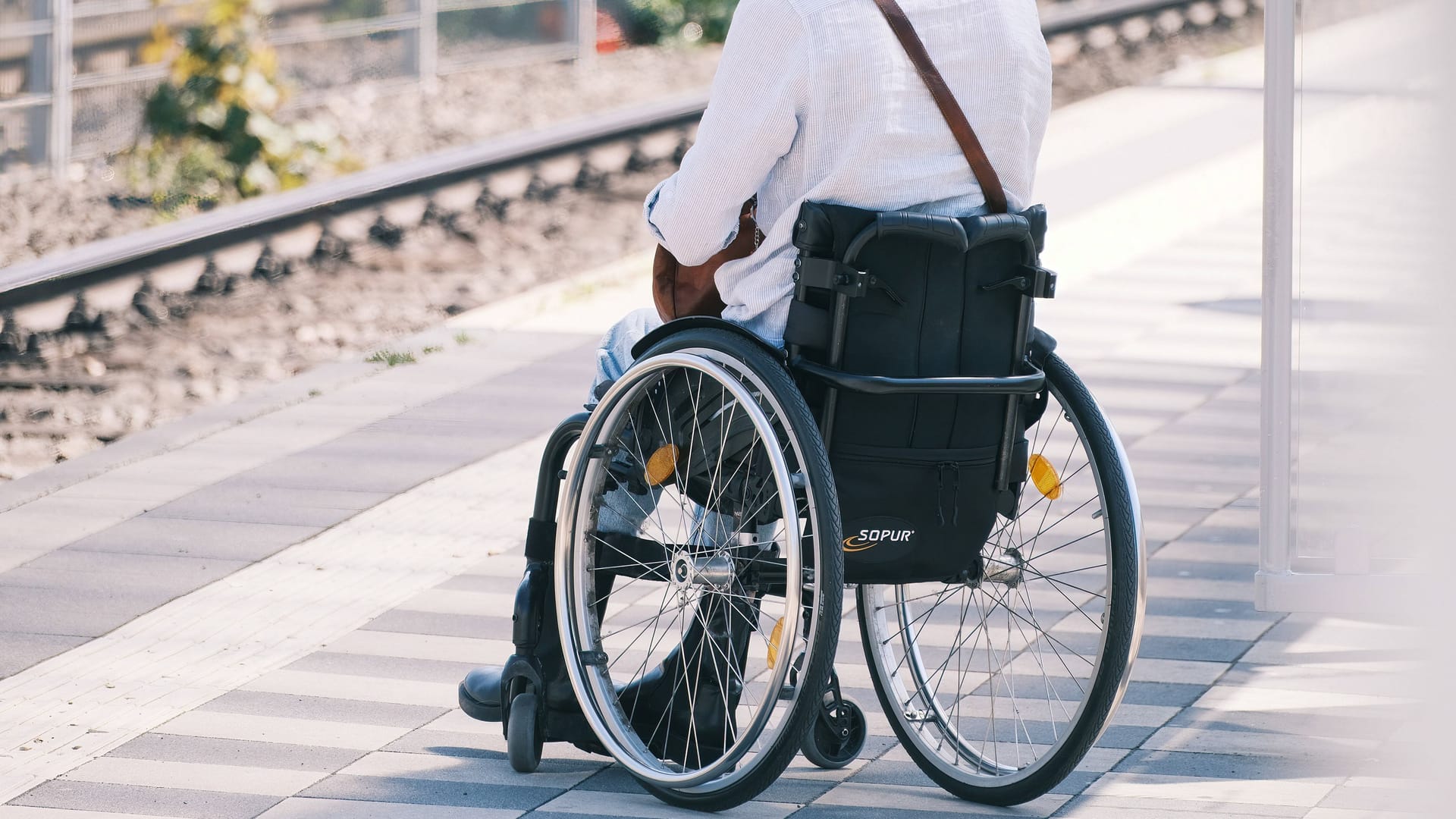 Rollstuhlfahrer an einem Bahnsteig (Symbolbild): Der SoVD kritisiert die mangelnde Barrierefreiheit im ÖPNV.