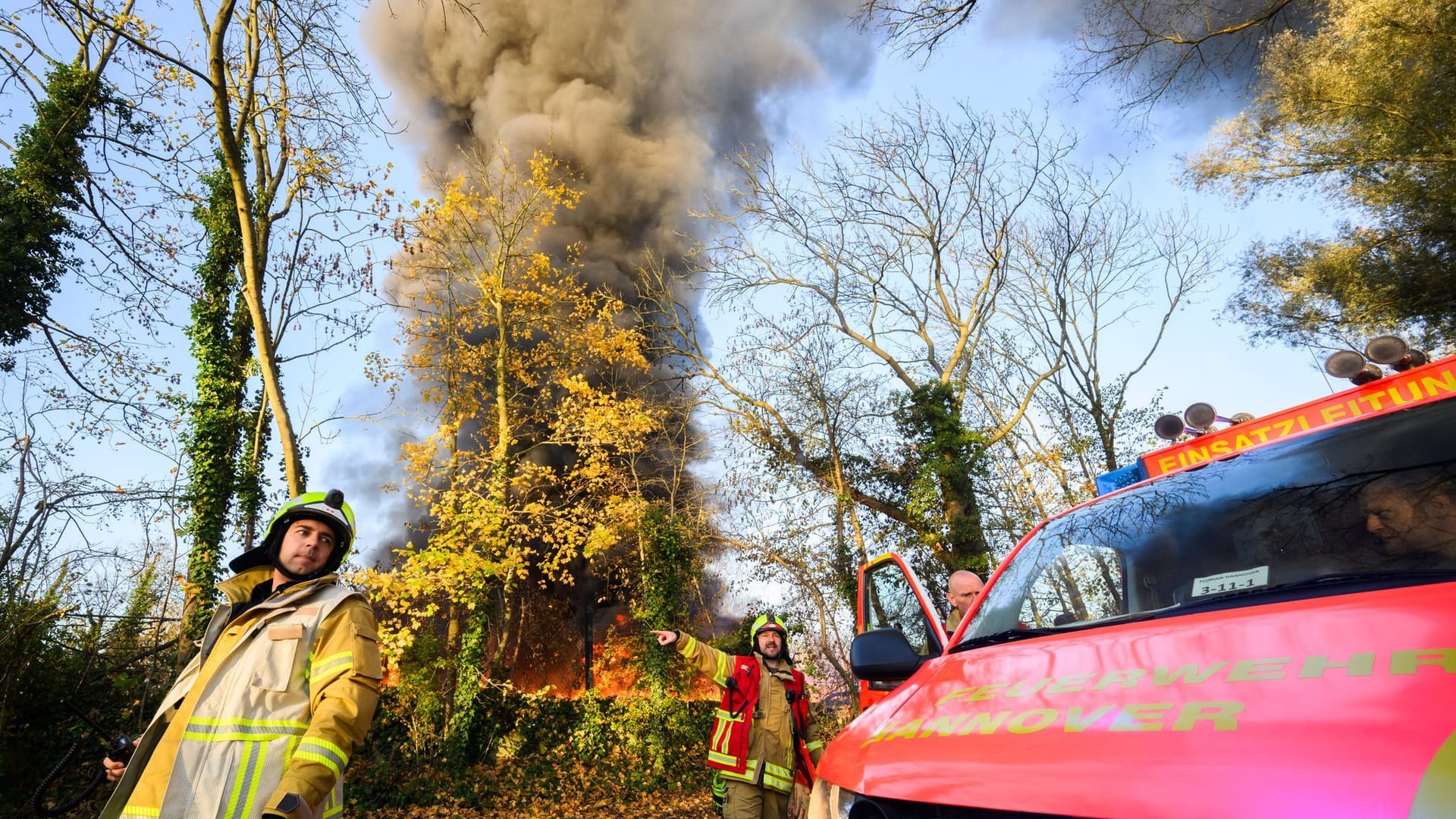 Feuerwehrkräfte stehen vor einem brennenden Lager für mobile Toiletten: Die Rauchwolke war kilometerweit zu sehen.