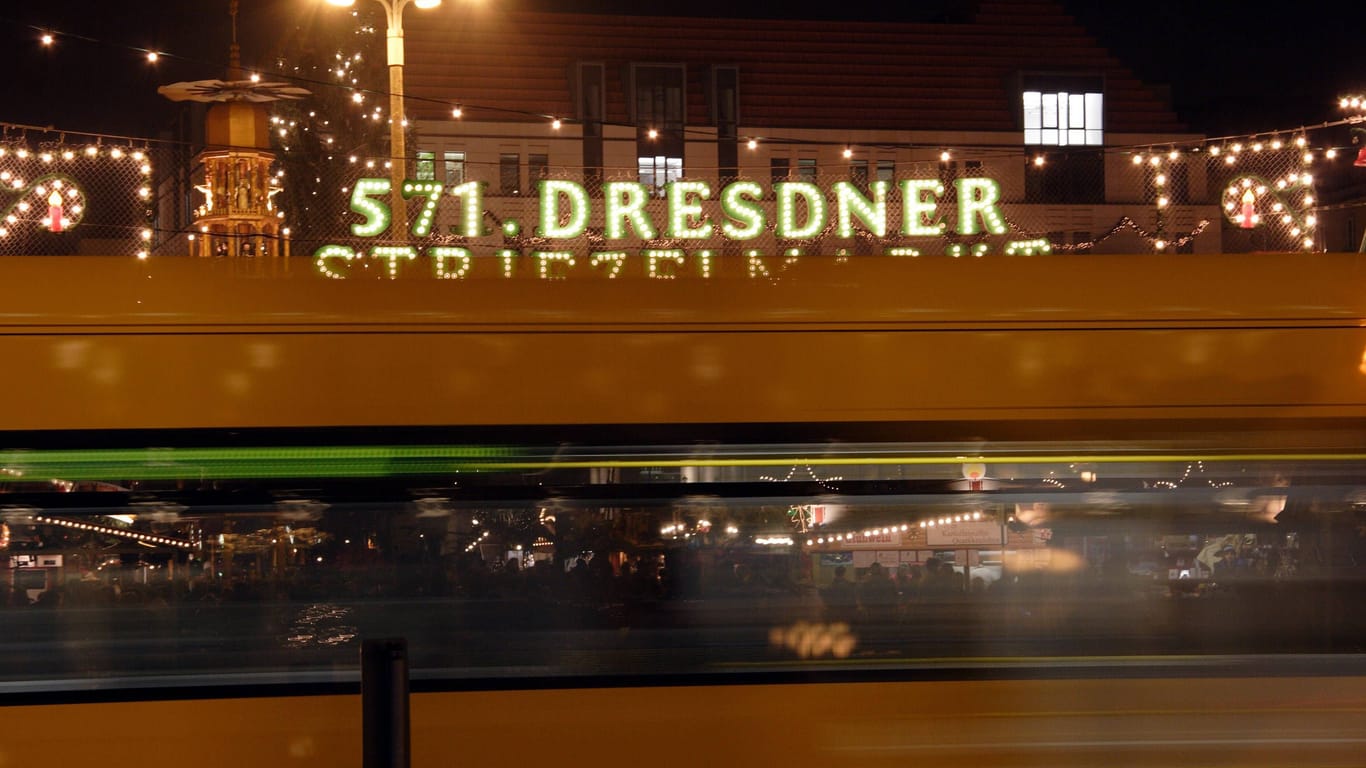 Die Straßenbahn rauscht am Eingang des Dresdener Weihnachtsmarkts (Archivbild): Die Stadt will für entspannte und verkehrsarme Weihnachtsmarkt-Besuche sorgen.