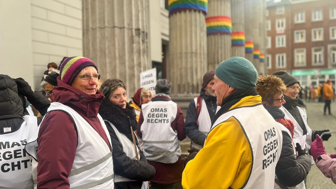 Die "Omas gegen Rechts" stehen pünktlich auf dem Theaterplatz: Das Theater ist in Regenbogenfahnen gehüllt