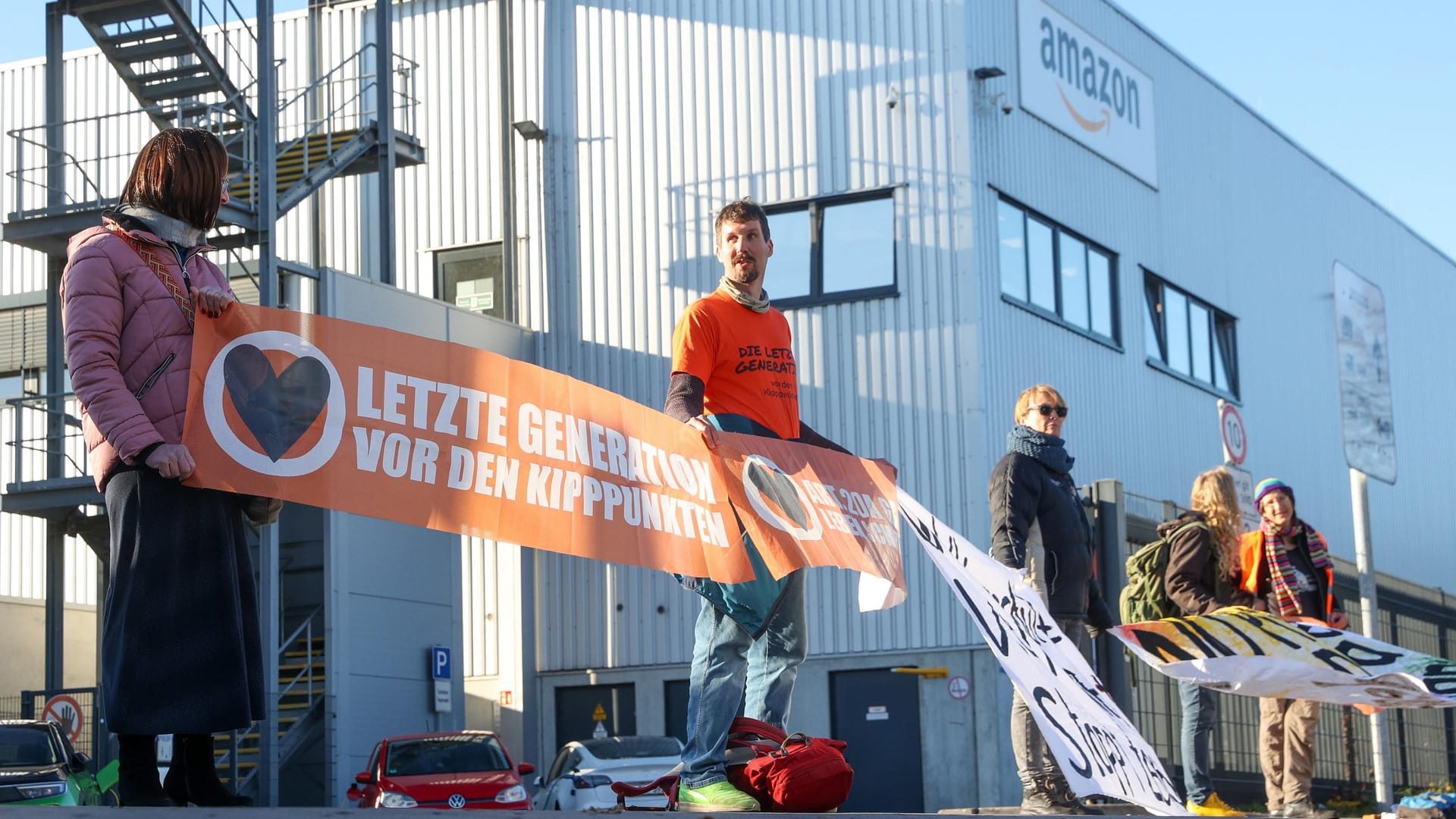 Mitglieder der "Letzten Generation" protestieren vor dem Amazon Verteilerzentrum in Hamburg.