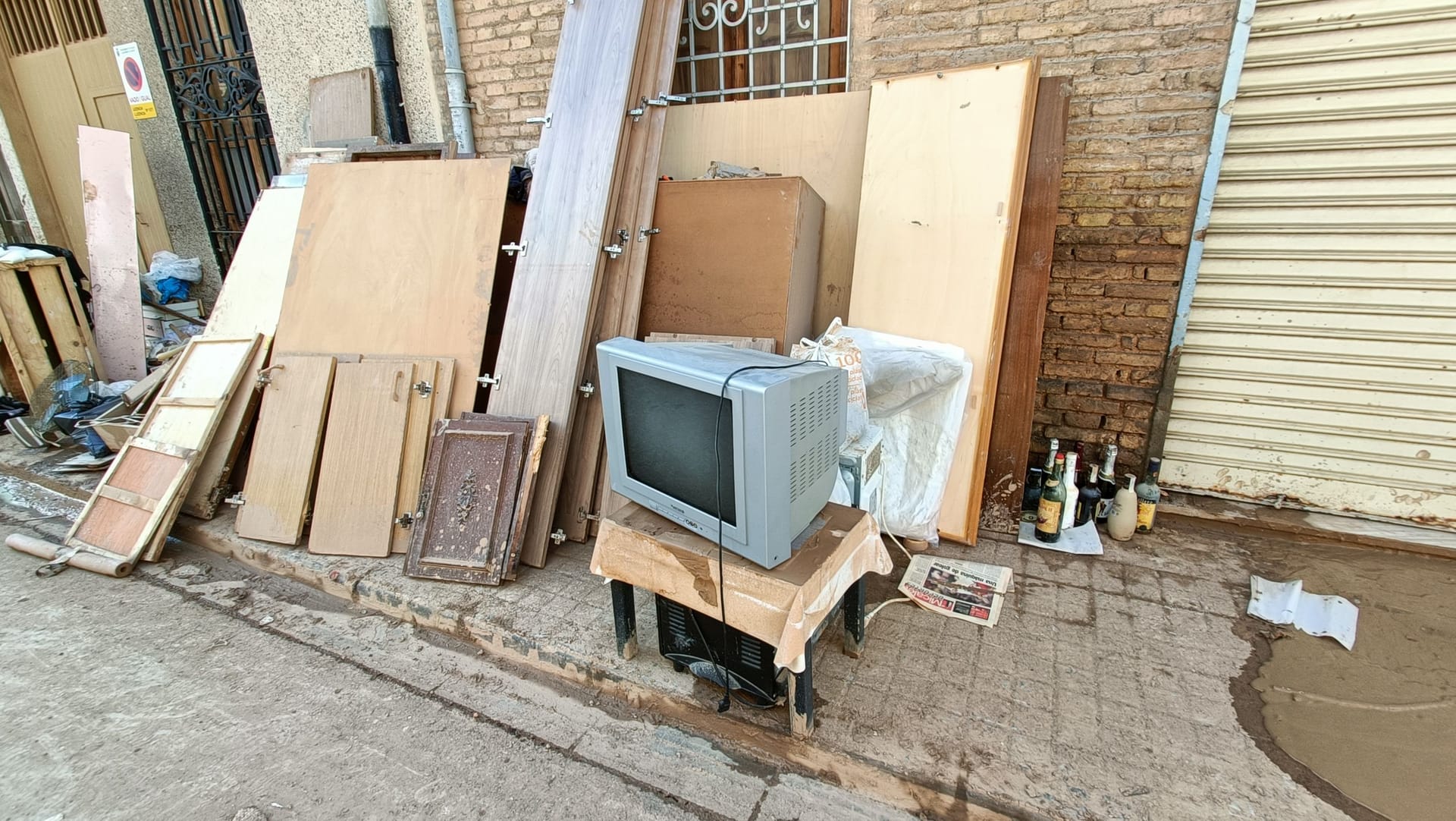 Ein zerstörter Fernseher steht während der Aufräumarbeiten auf der Straße.