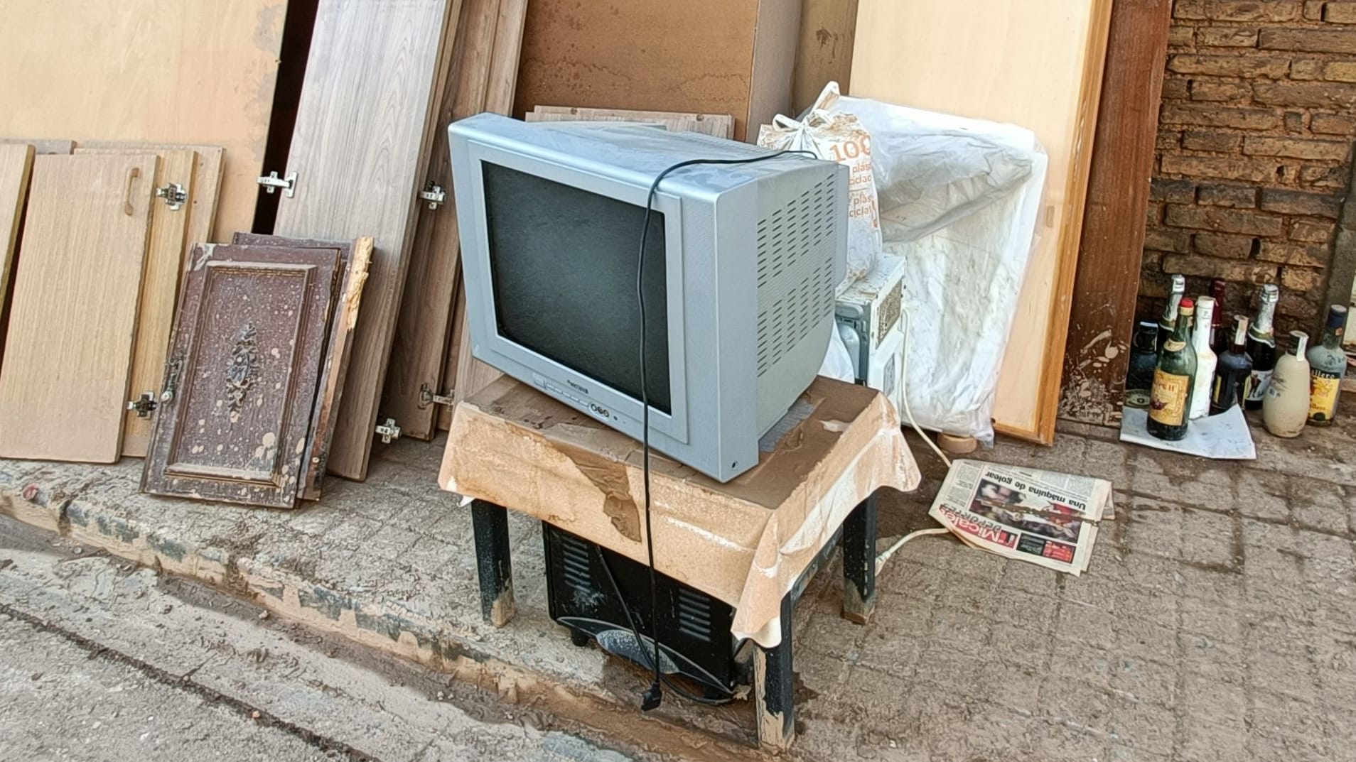 Ein zerstörter Fernseher steht während der Aufräumarbeiten auf der Straße.