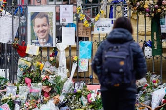 Eine Frau steht am Marktplatz an der Trauerstelle für den getöteten Polizisten (Archivbild): Die Bundesanwaltschaft hat den Angreifer angeklagt.