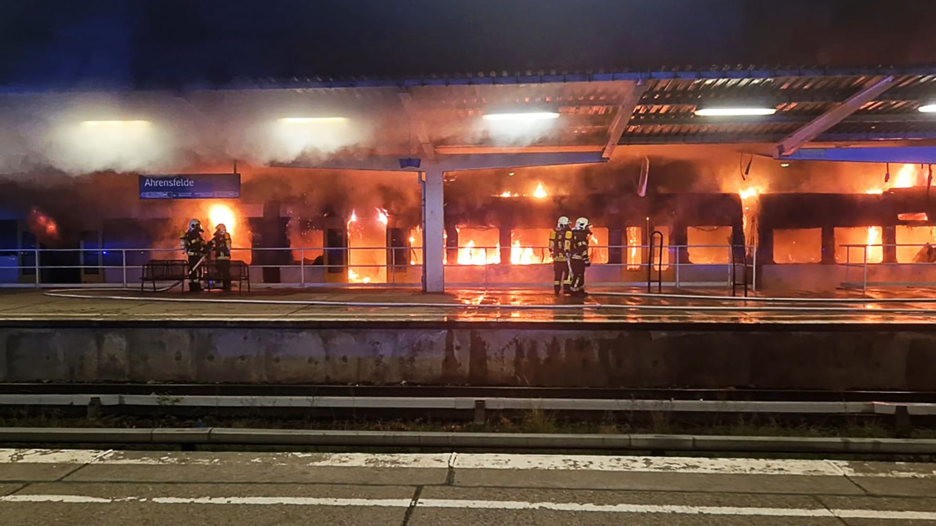 Einsatzkräfte der Feuerwehr löschen den Brand eines Zuges im S-Bahnhof Ahrensfelde