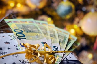 Weihnachtsgeschenk mit Geld (Symbolbild): In manchen Branchen erhalten alle Beschäftigten Weihnachtsgeld.