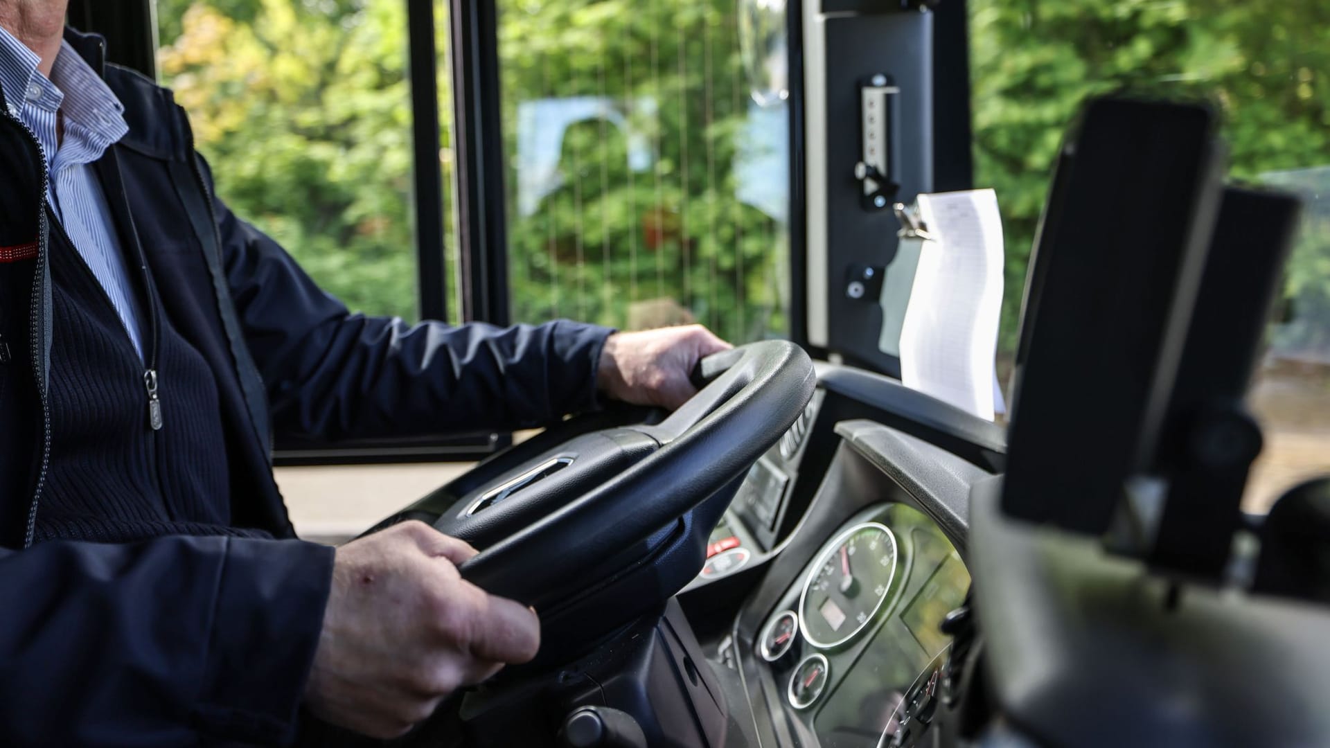 Ein Busfahrer am Lenkrad.