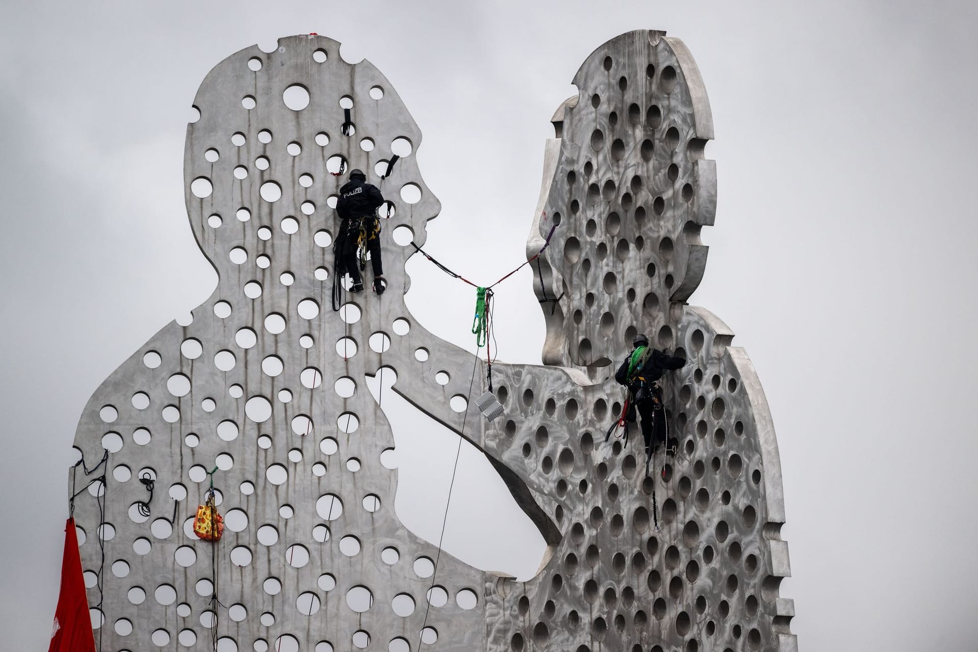 Aktivisten klettern auf Skulptur Molecule Man in der Spree