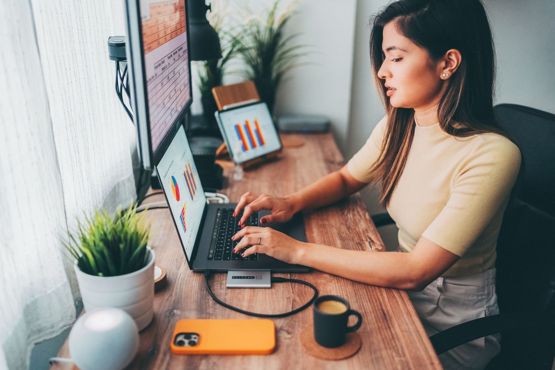 Frau sitzt am Computer und wertet Statistiken aus