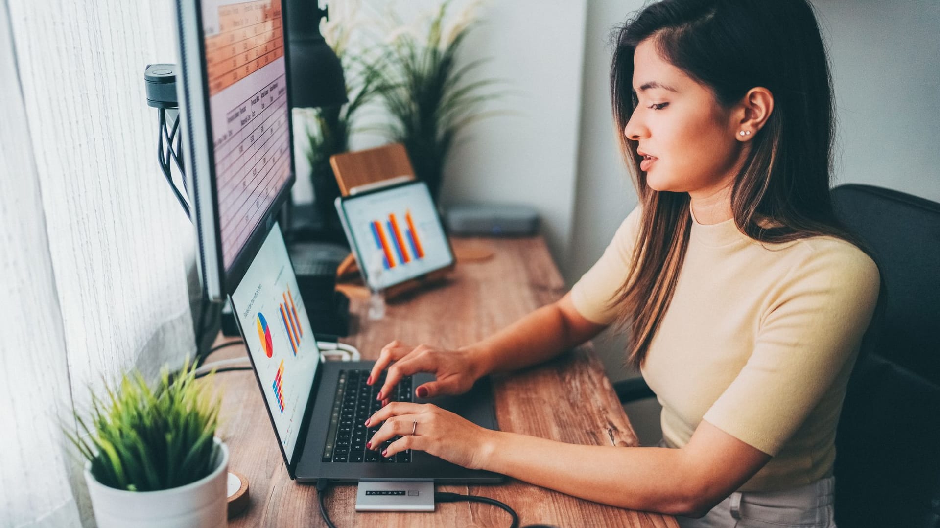 Frau sitzt am Computer und wertet Statistiken aus