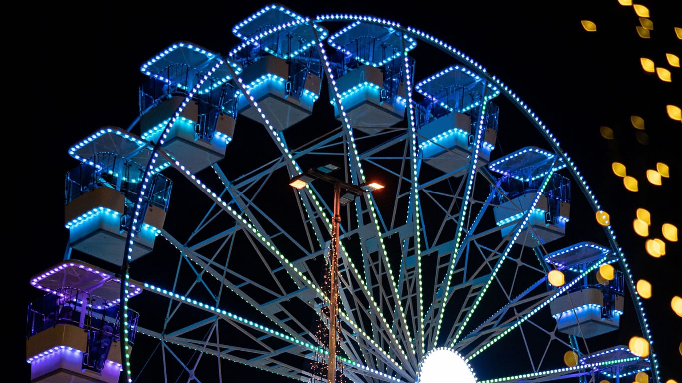 Ein bunt beleuchtetes Riesenrad wartet in der "Winterworld" auf Fahrgäste.