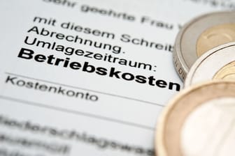 Münzen liegen auf einer Betriebskostenabrechnung