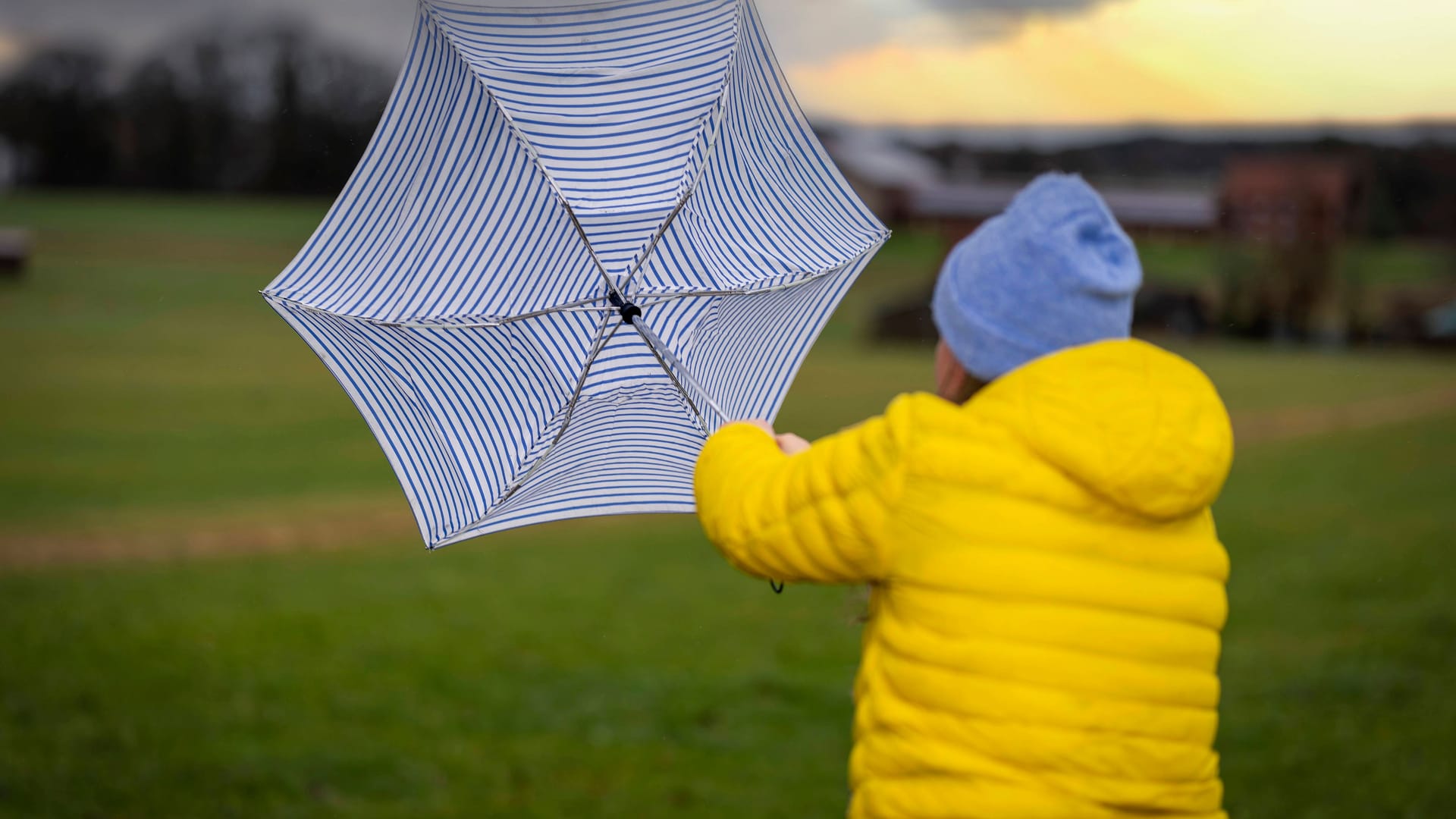 Eine Frau kämpft mit ihrem Regenschirm gegen den Sturm an. (Symbolfoto)