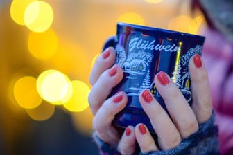 Frau hält Tasse mit Glühwein in den Händen