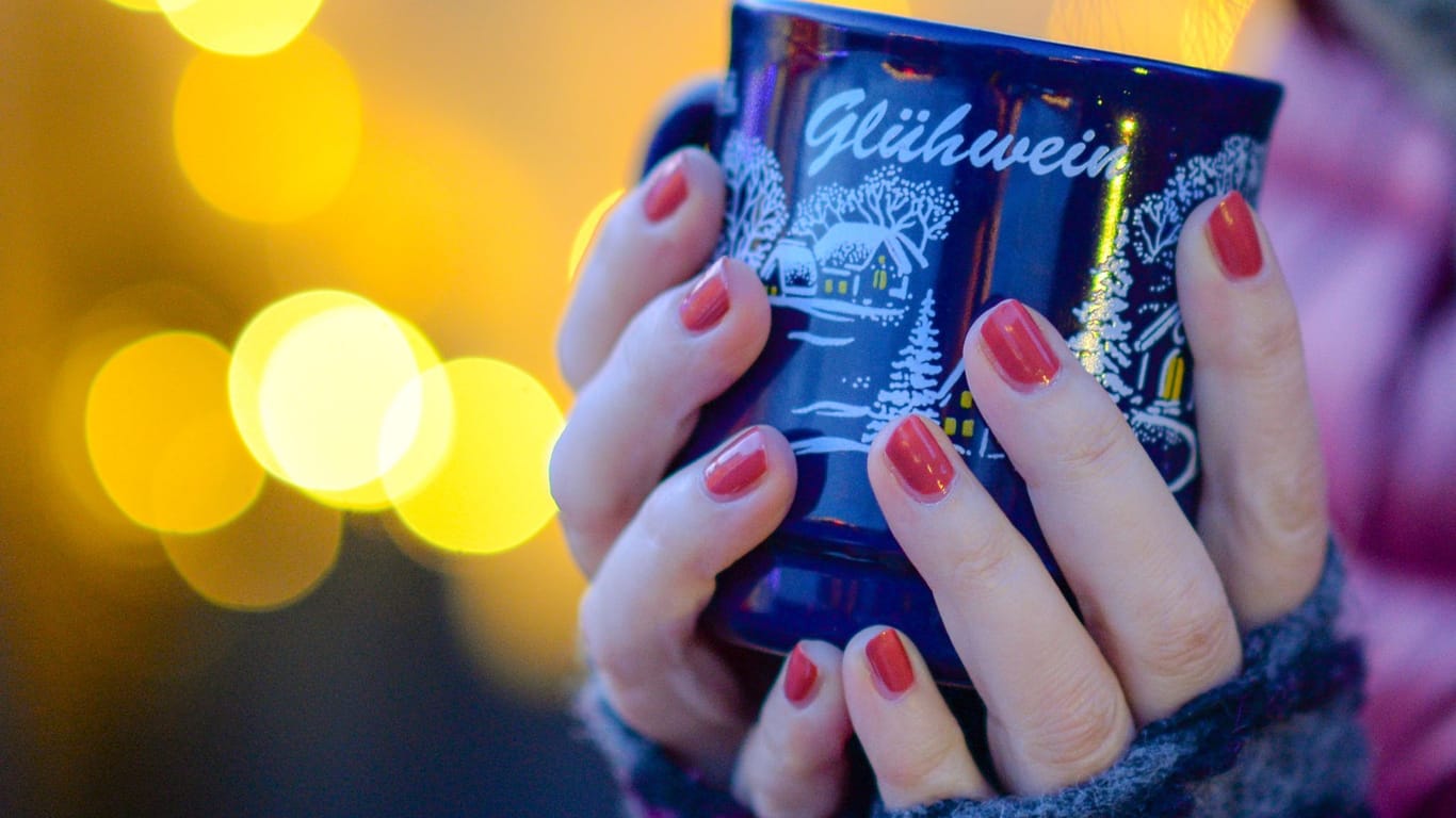 Frau hält Tasse mit Glühwein in den Händen