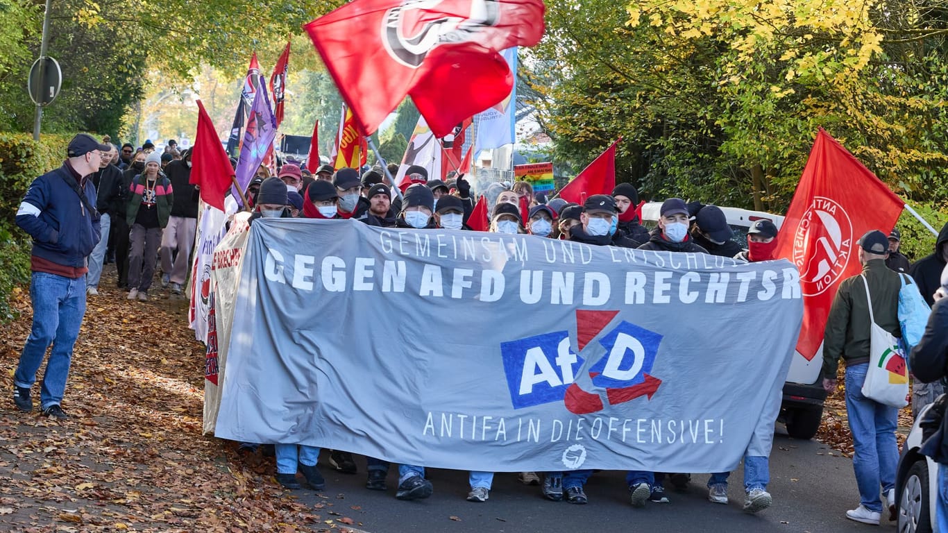 Teilnehmer einer Demonstration gegen den Landesparteitag der AfD Schleswig-Holstein im Bürgerhaus: Sie halten auf der Beckersbergstraße ein Transparent mit der Aufschrift "Gemeinsam und entschlossen gegen AfD und Rechts Antifa in die Offensive" hoch.