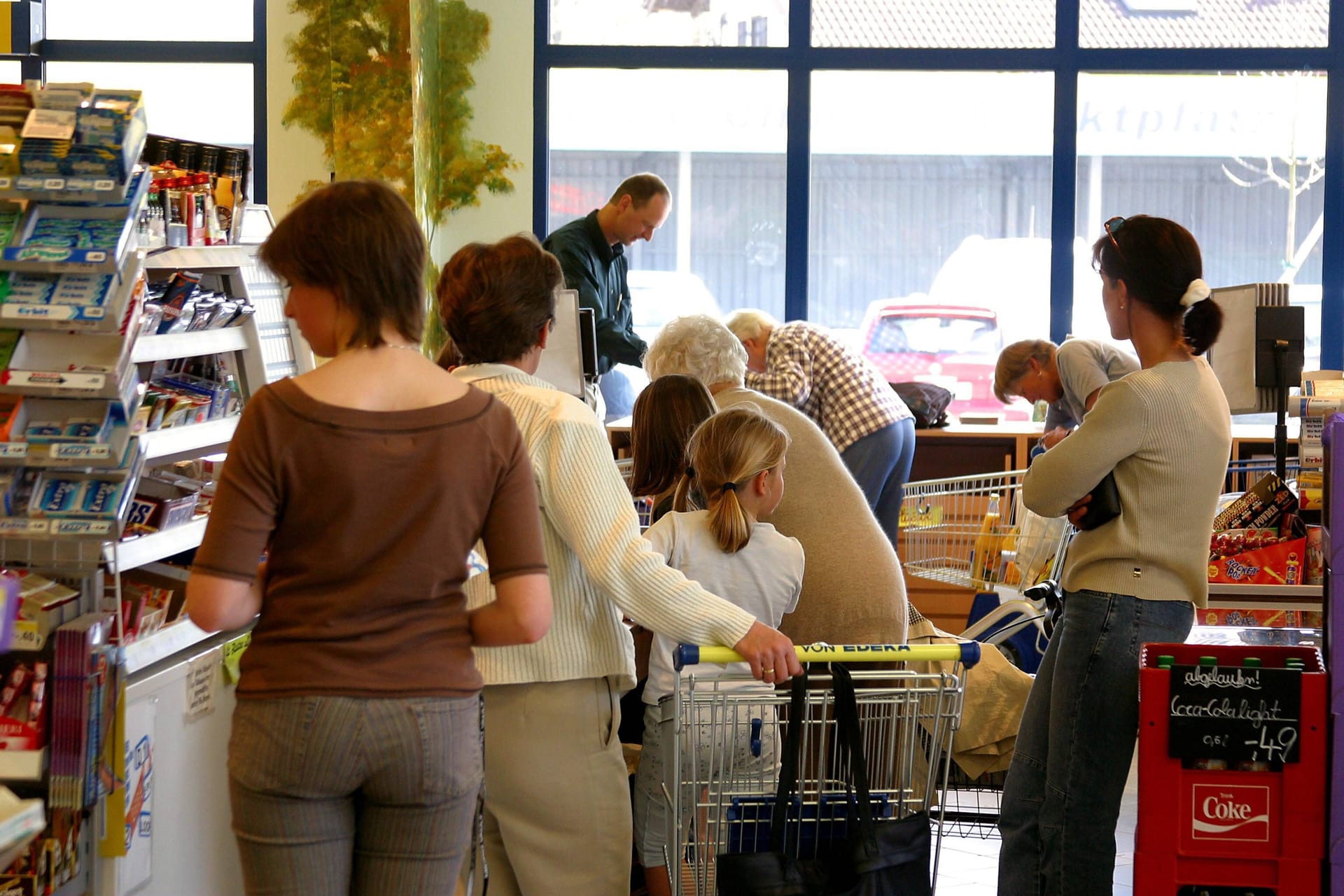 In der Schlange: Kunden eines Supermarktes warten an der Kasse, bis sie an die Reihe kommen.