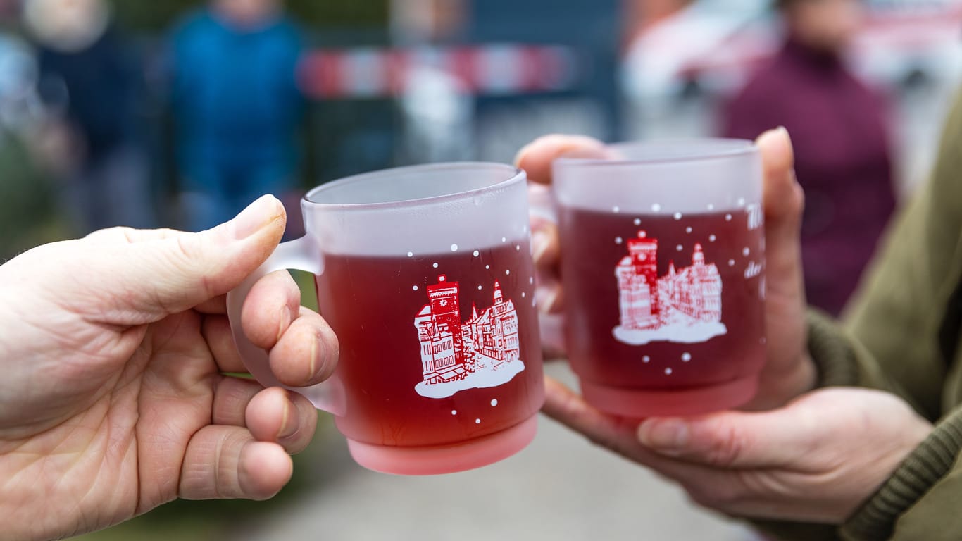 Menschen halten Tassen mit Glühwein in den Händen (Symbolbild): In Findorff wird bereits Glühwein ausgeschenkt.