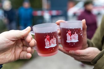 Menschen halten Tassen mit Glühwein in den Händen (Symbolbild): In Findorff wird bereits Glühwein ausgeschenkt.