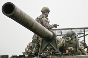 Russische Soldaten auf einem Panzer (Symbolbild): Die Ukraine hat Ermittlungen gegen Russland eingeleitet.