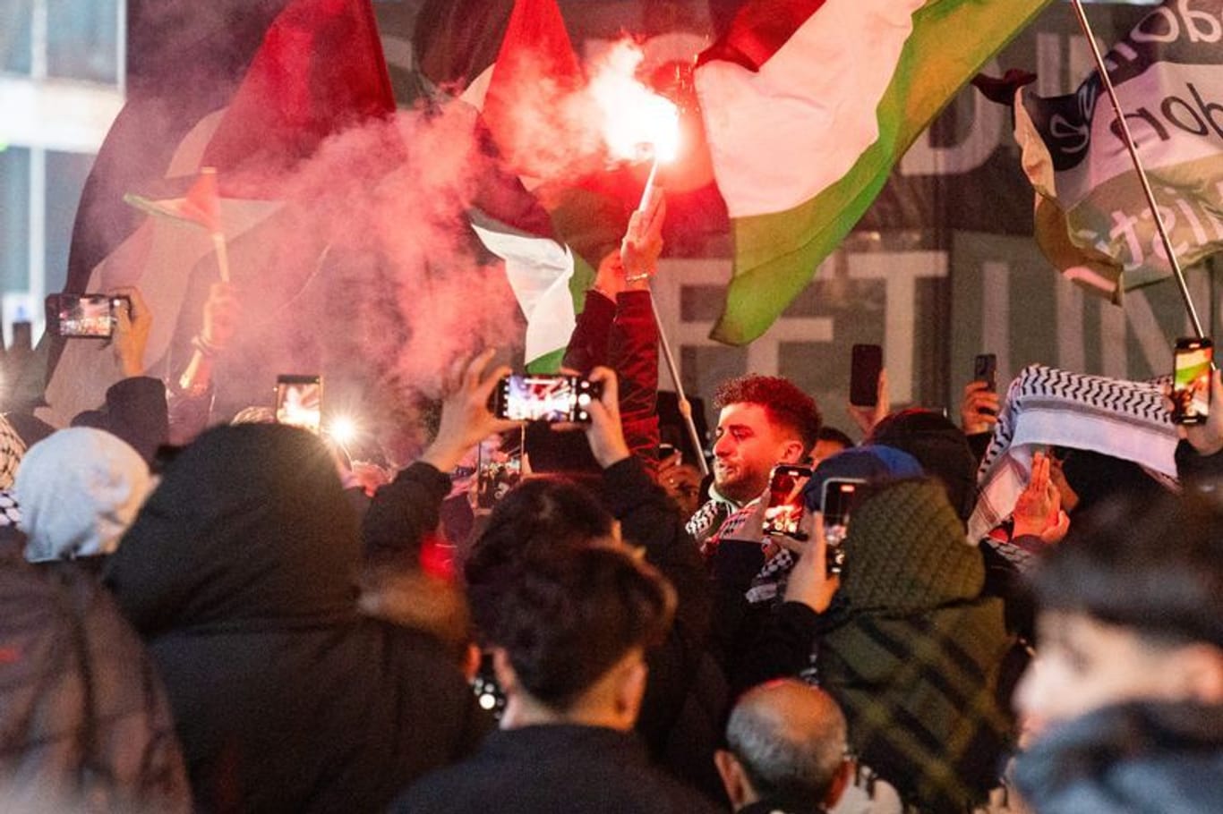 Ein Teilnehmer einer propalästinensischen Demonstration hält eine bengalische Fackel: Mehrere Hundert Menschen demonstrierten für Solidarität mit Palästina. Sie forderten unter anderem ein Ende der Waffenlieferungen nach Israel und ein Ende des Kriegs im Gazastreifen.