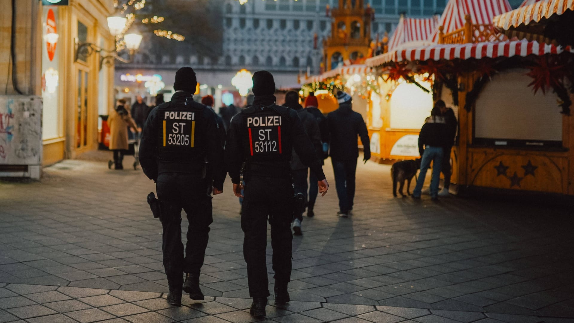 Polizisten laufen auf dem Magdeburger Weihnachtsmarkt Streife.