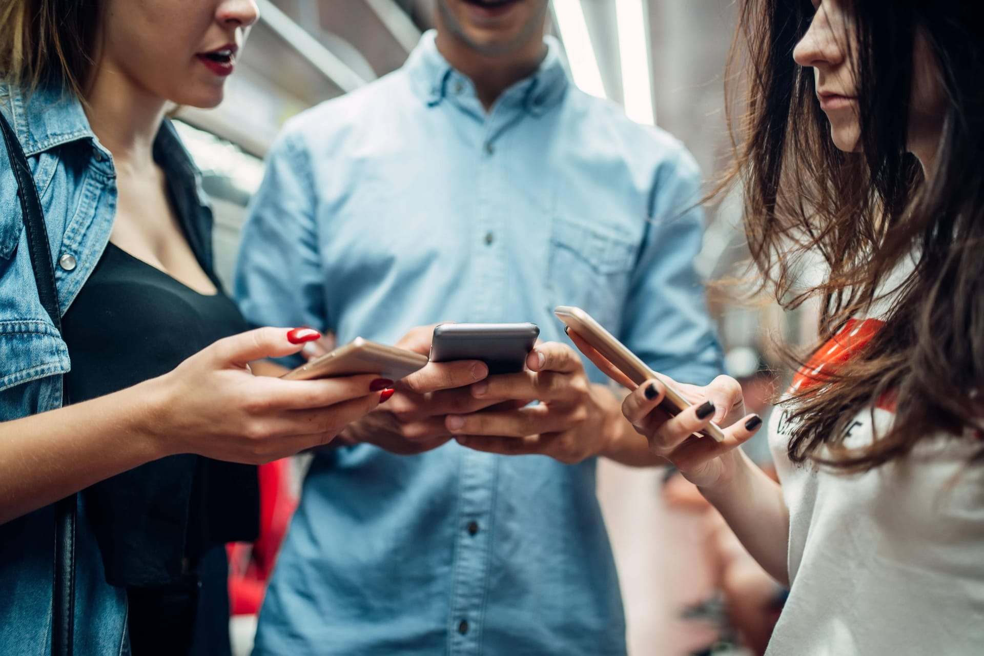 Mehrere Personen stehen mit Smartphones in der Hand in einer U-Bahn (Symbolbild):