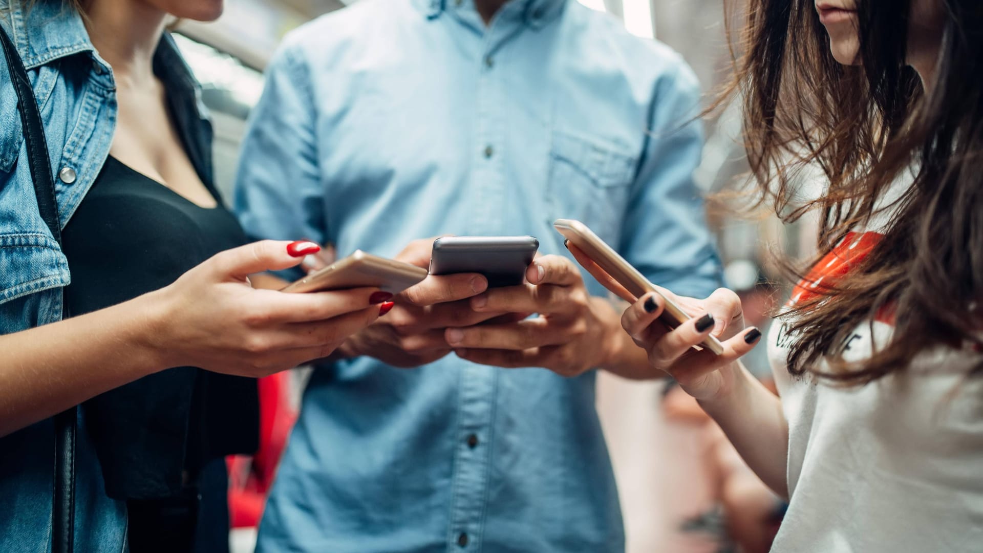 Mehrere Personen stehen mit Smartphones in der Hand in einer U-Bahn (Symbolbild):