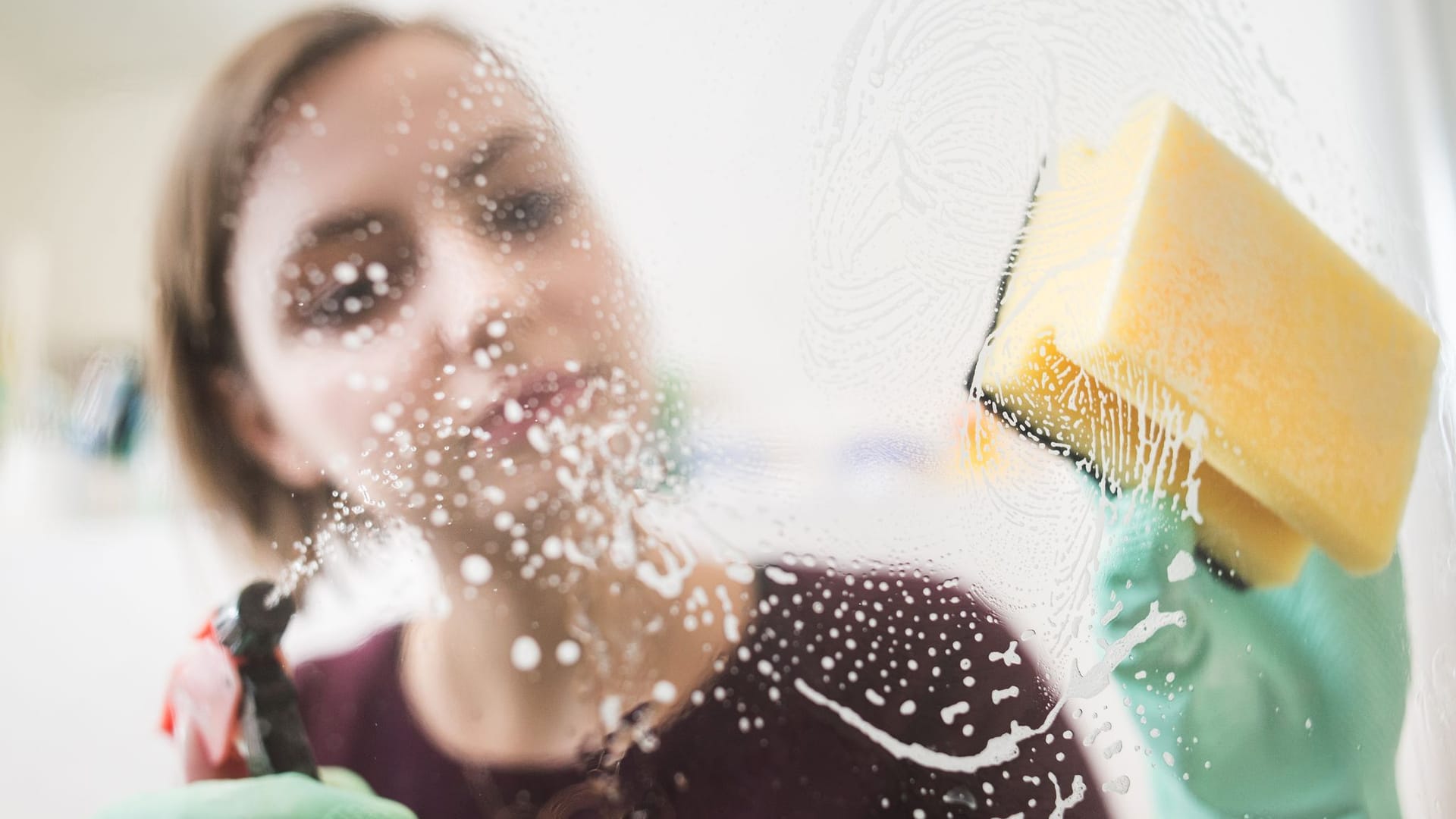 Frau putzt die Dusche im Badezimmer