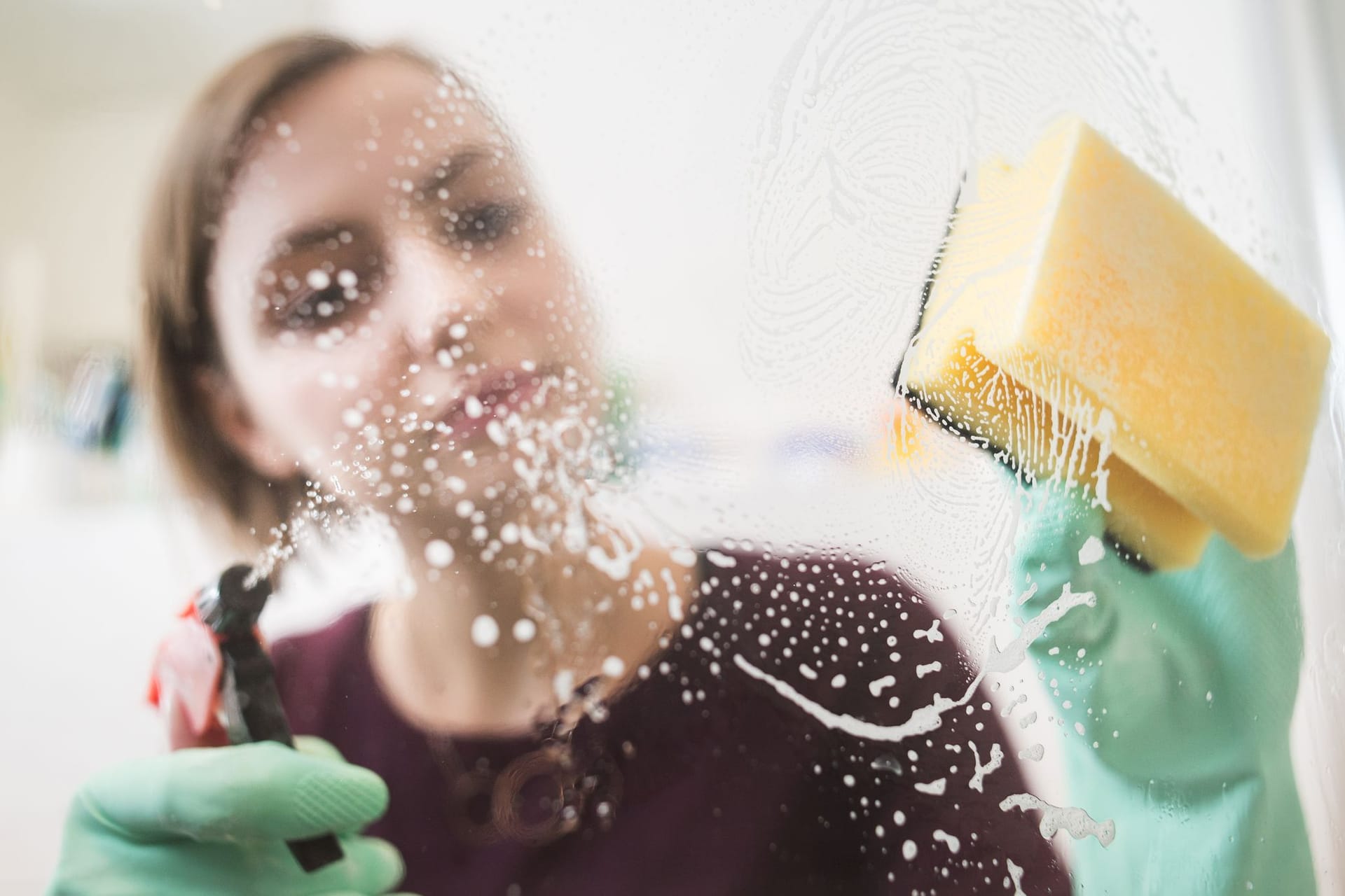 Frau putzt die Dusche im Badezimmer