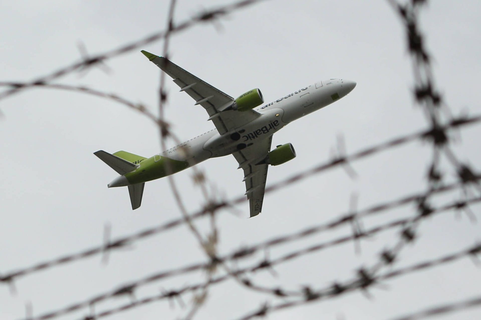 Eine Maschine der Air Baltic fliegt über einen Gitterzaun am Flughafen Hamburg (Symbolbild): Die Innenbehörde hat die Abschiebung von Straftätern intensiviert.